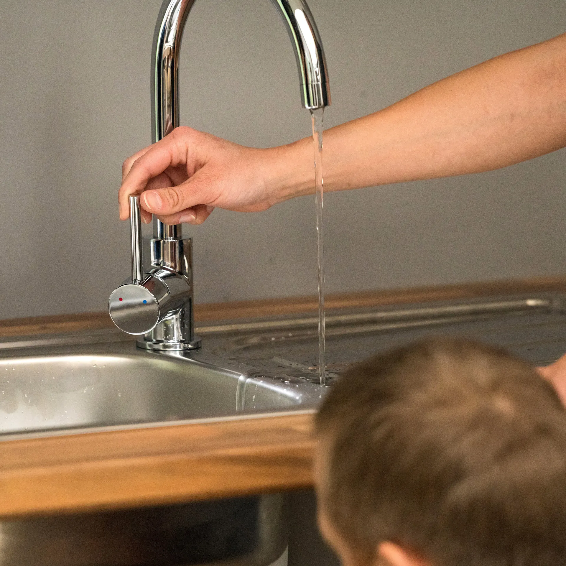 Heimwerker betätigt Wasserhahn.
