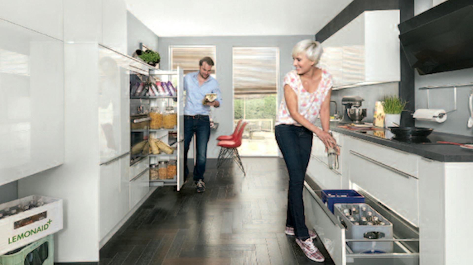 Paar räume Lebensmittel in Küchenschränke und Kühlschrank in weißer Küche ein.