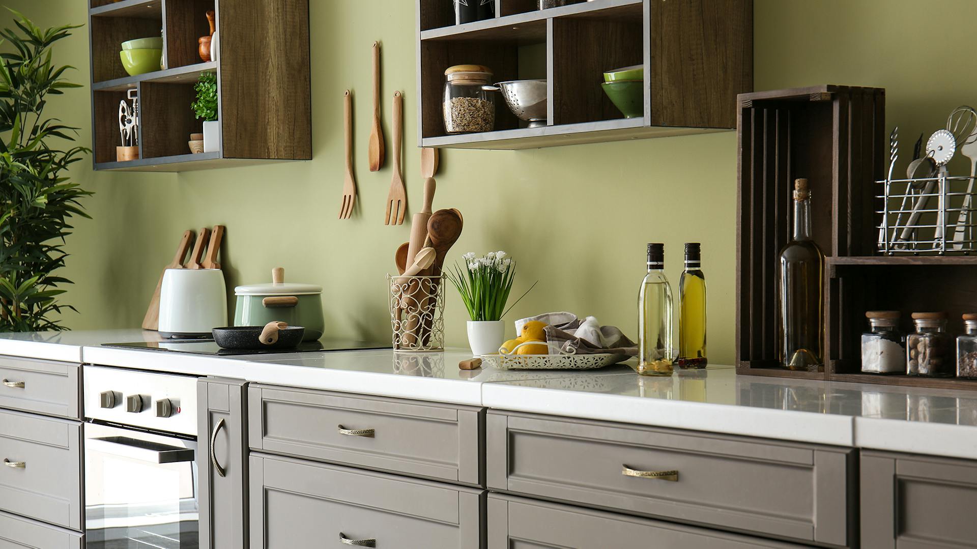 Mintfarbene Wand, davor ein Waschtisch mit weißem Waschbecken. Darüber ein sechseckiger Spiegel.