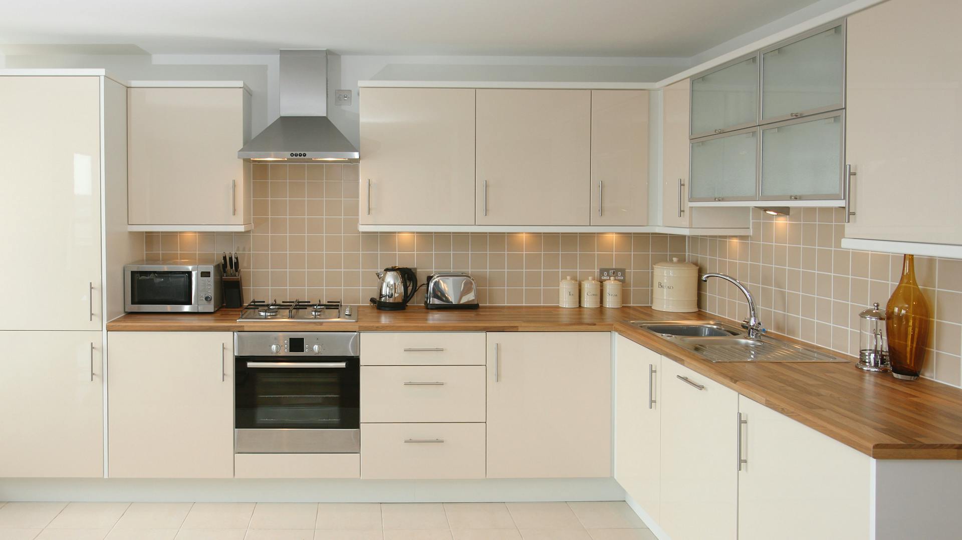 Beige Küchenzeile mit Holz-Arbeitsplatte.