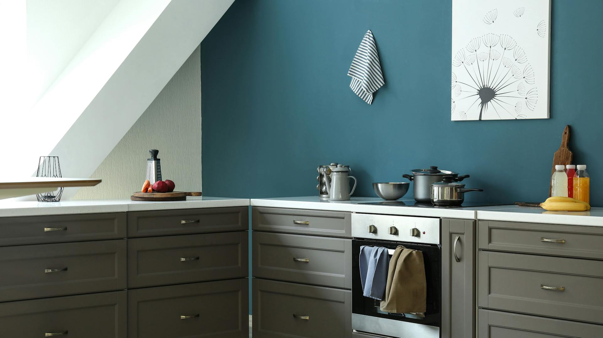 Dunkelgraue Küchenzeile vor einer dunkelblauen Wand.