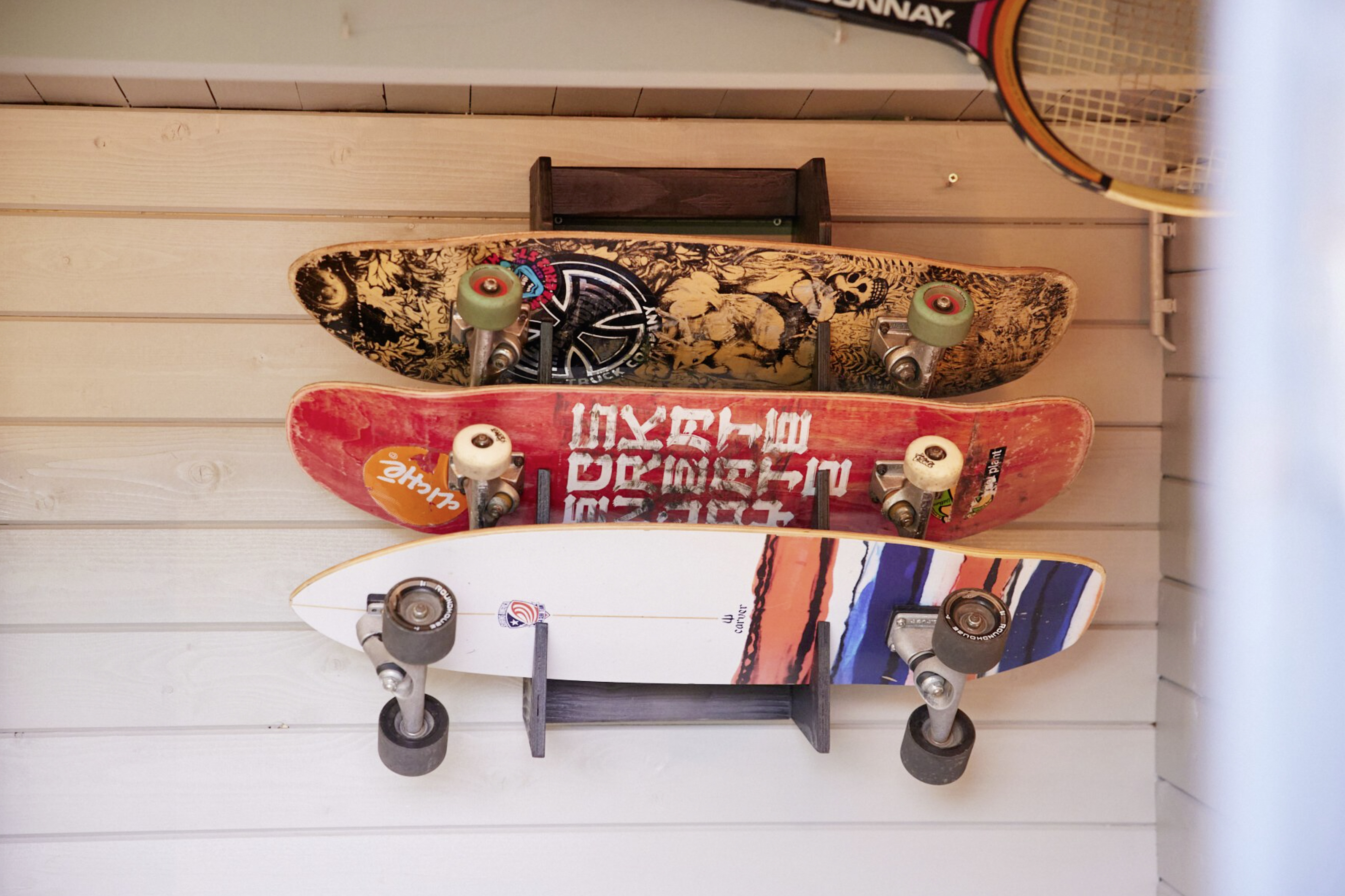 Drei Skatesboards hängen an einem selbstgebauten Regal