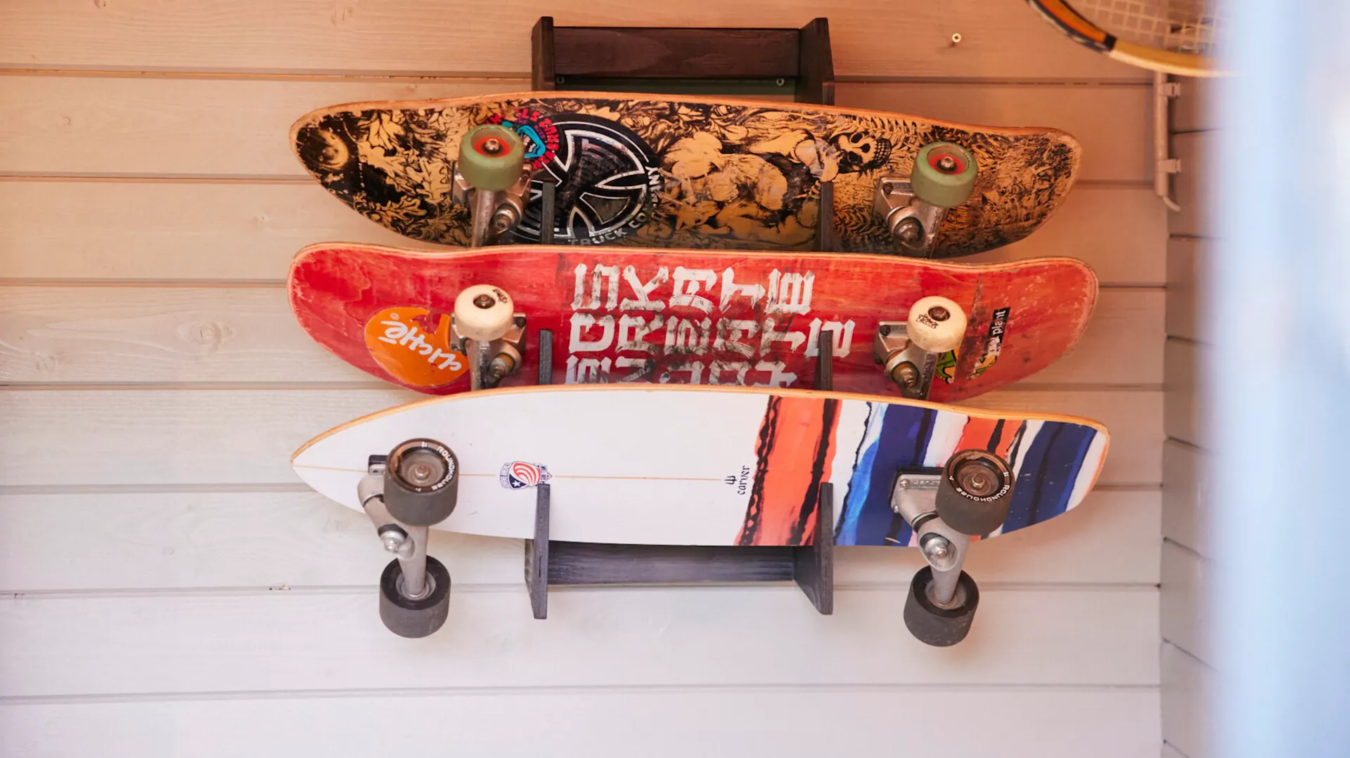 Drei Skatesboards hängen an einem selbstgebauten Regal