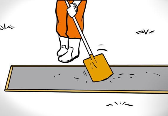 Heimwerker verdichtet Beton in Fundamentgrube mit einem Spaten.