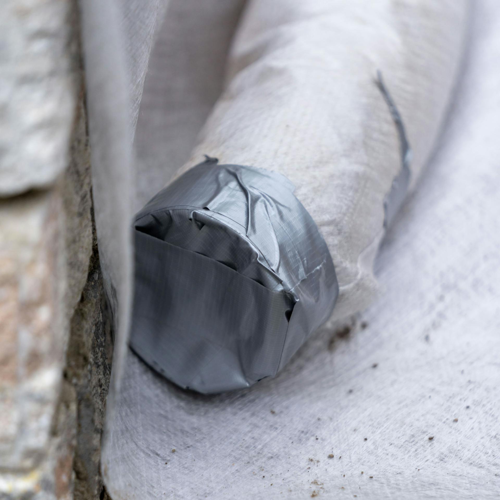 Mit Trennvlies umwickeltes Drainagerohr mit Klebeband