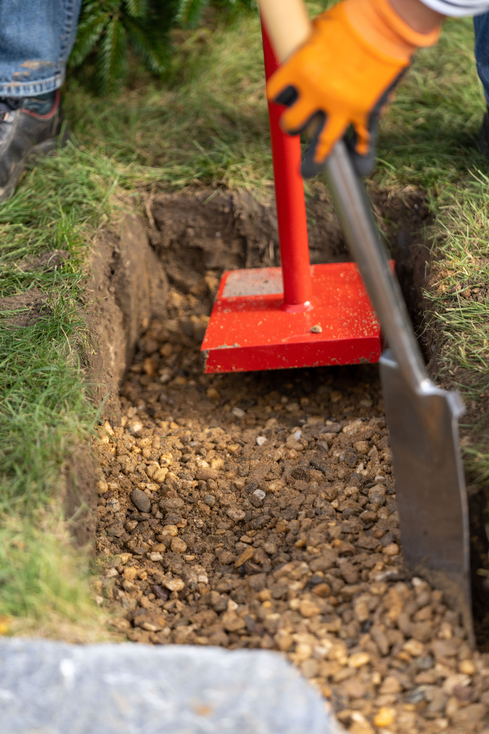 Compattatore manuale su uno strato portante di ghiaia
