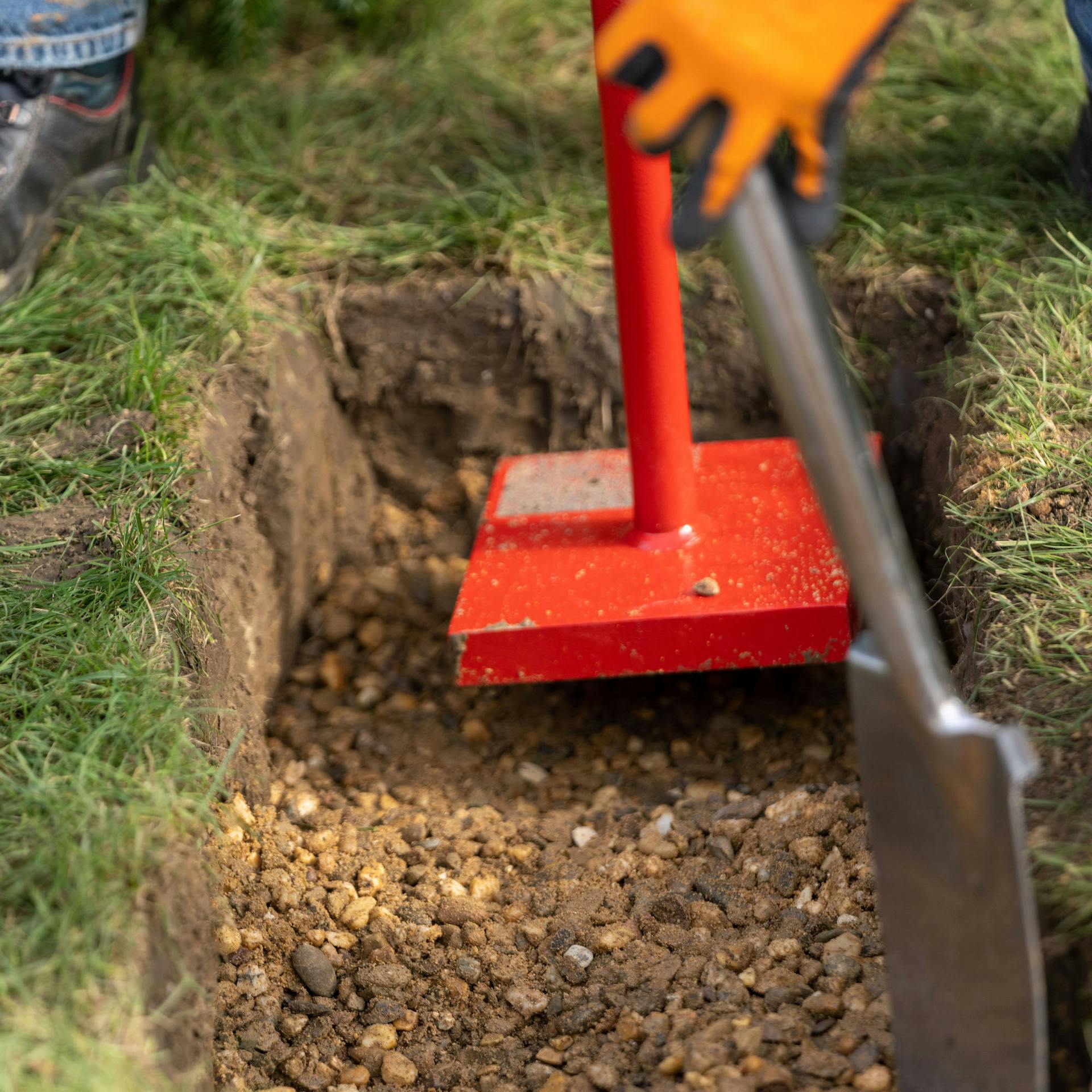 Handstampfer auf einer Tragschicht aus Kies