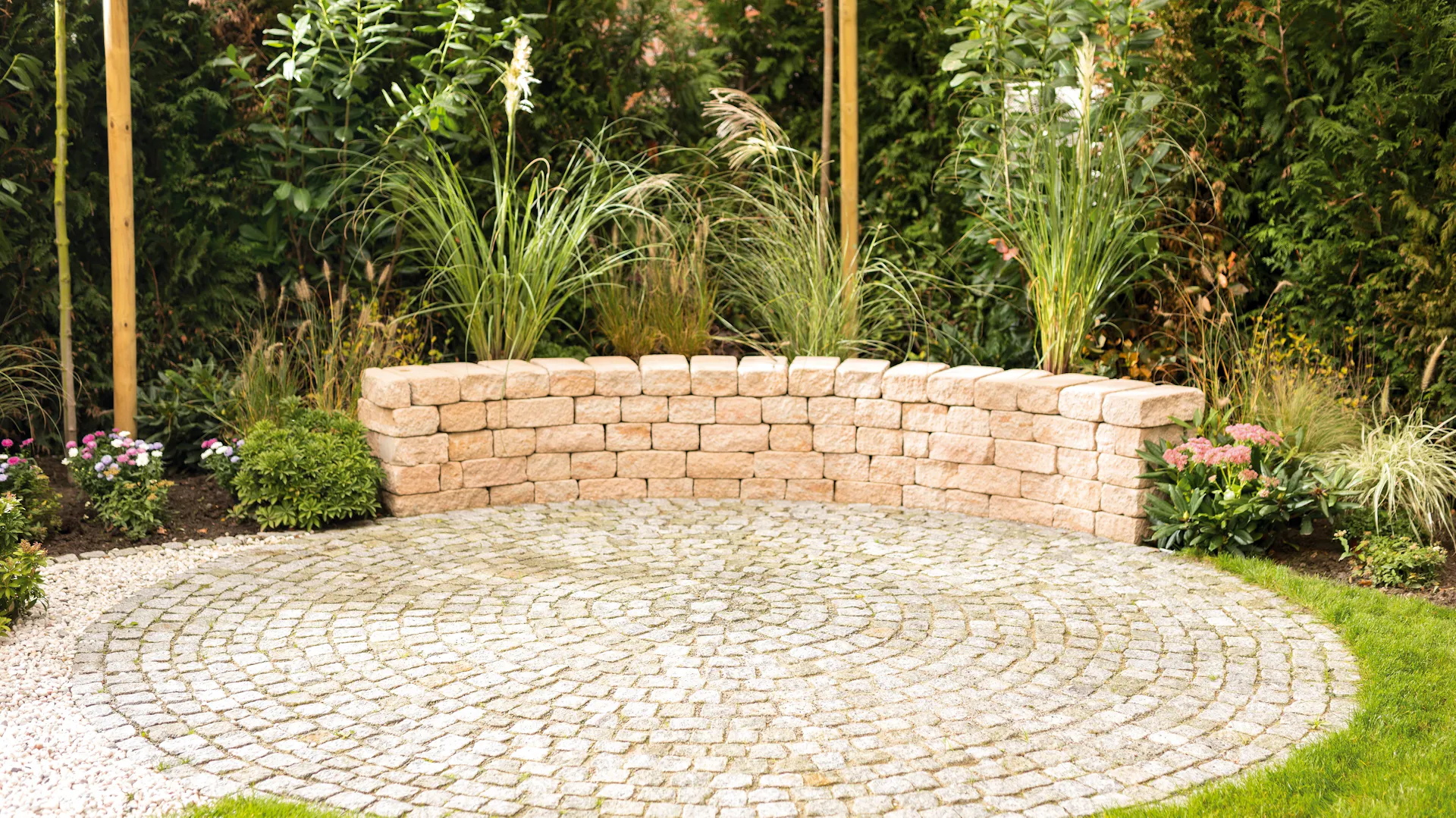 Kleine Mauer aus Sandsteinen als Umrandung für Sitzplatz im Garten