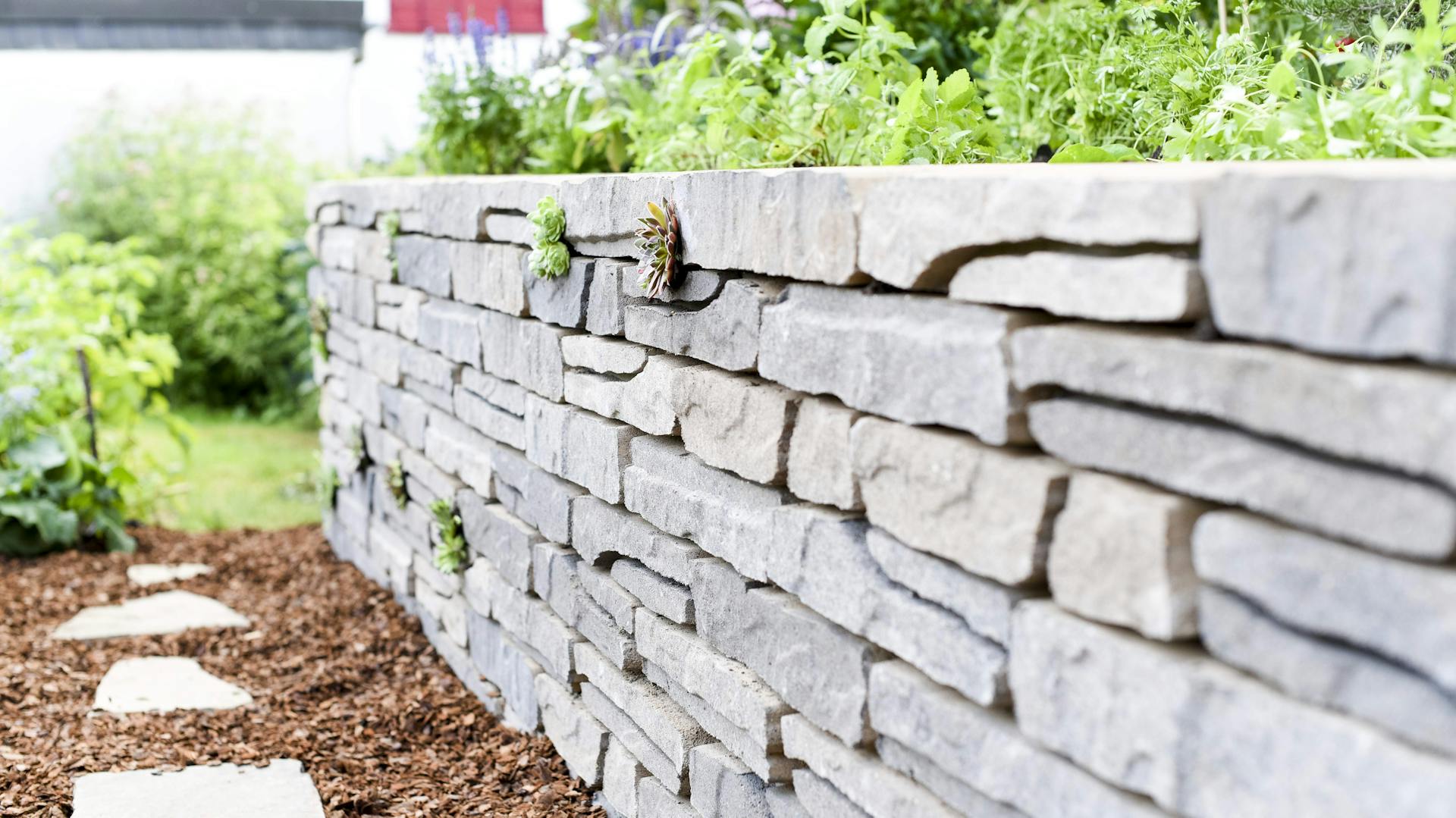 Mauer mit Gehweg im Garten.