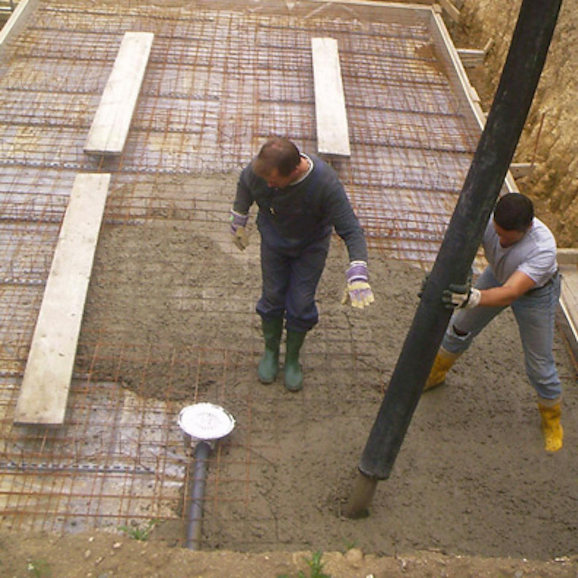 A barkácsolók lefektetik a medence alaplemezét.