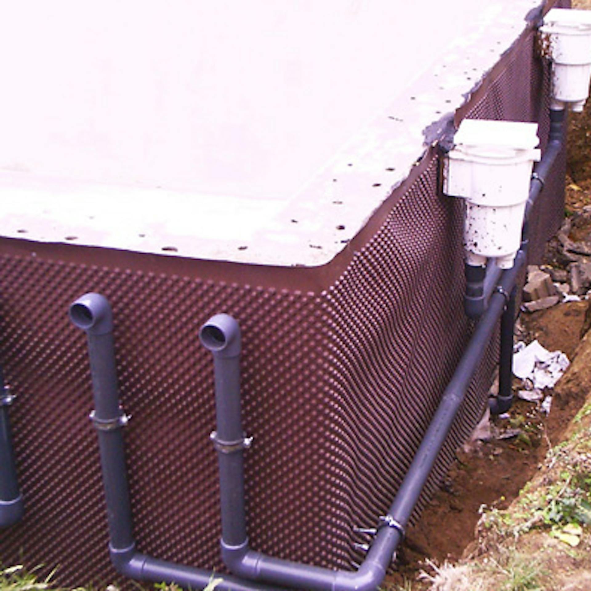 A be- és kivezető csövek a medence külső falán vannak elhelyezve.