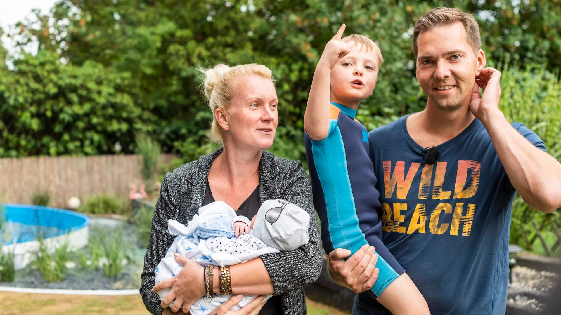 Familie mit Kind vor Pool
