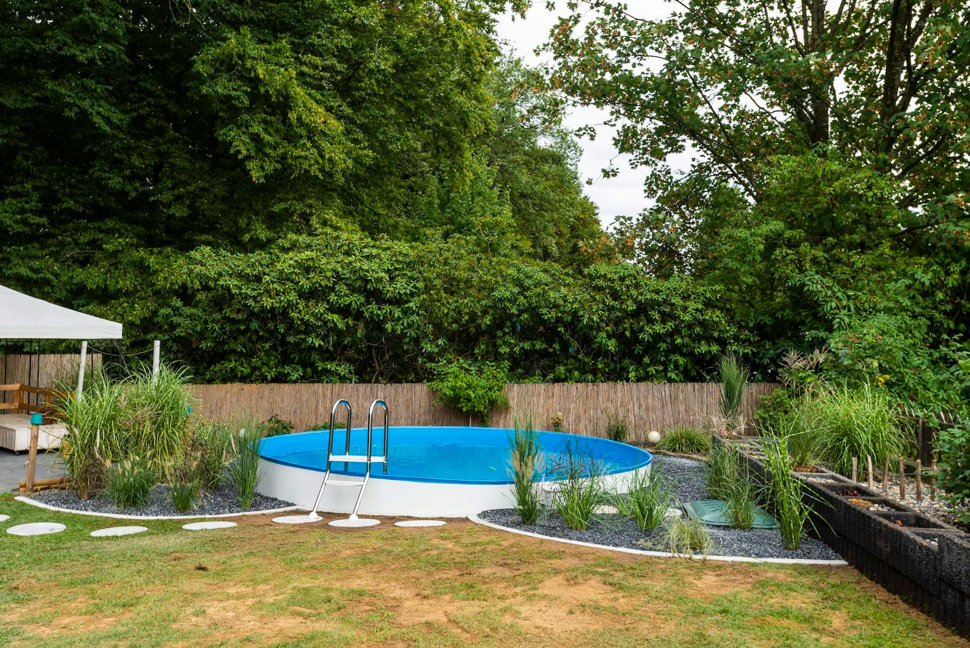 Piscina fuori terra rigida semi-interrata in giardino.