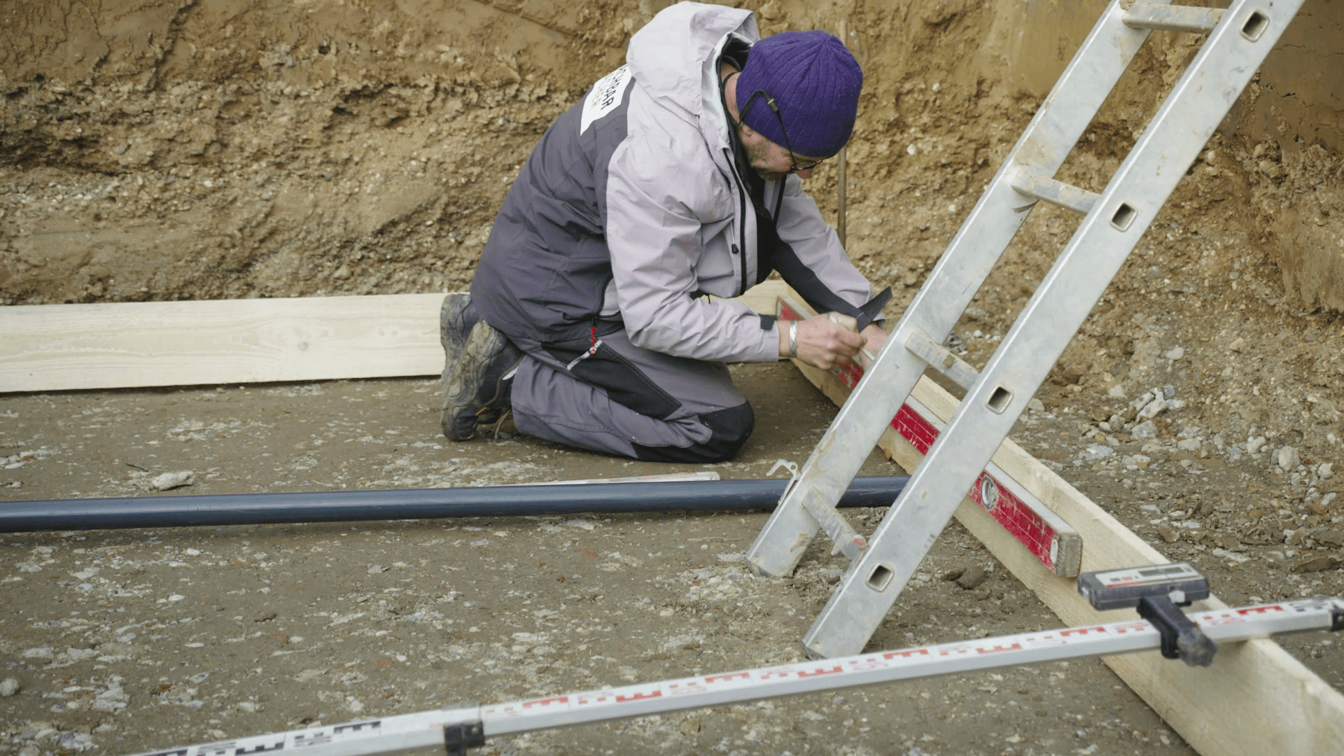 Heimwerker befestigt Schalrahmen aus Holz für Betonplatte.