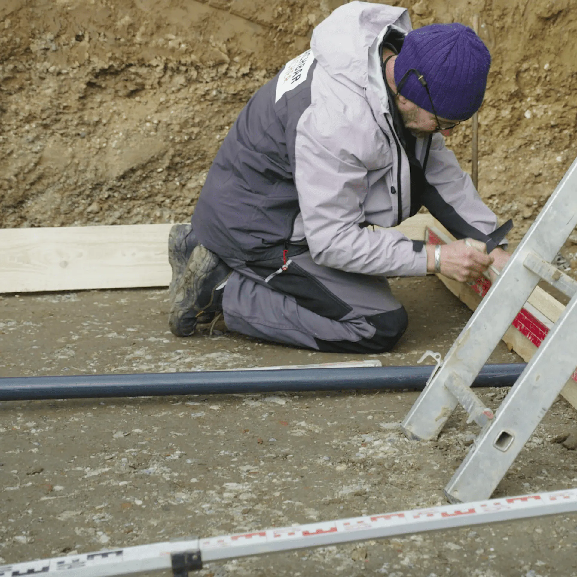 Heimwerker befestigt Schalrahmen aus Holz für Betonplatte.