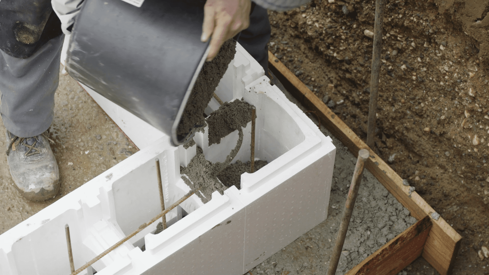 Heimwerker befüllt Polystyrolsteine mit Beton.