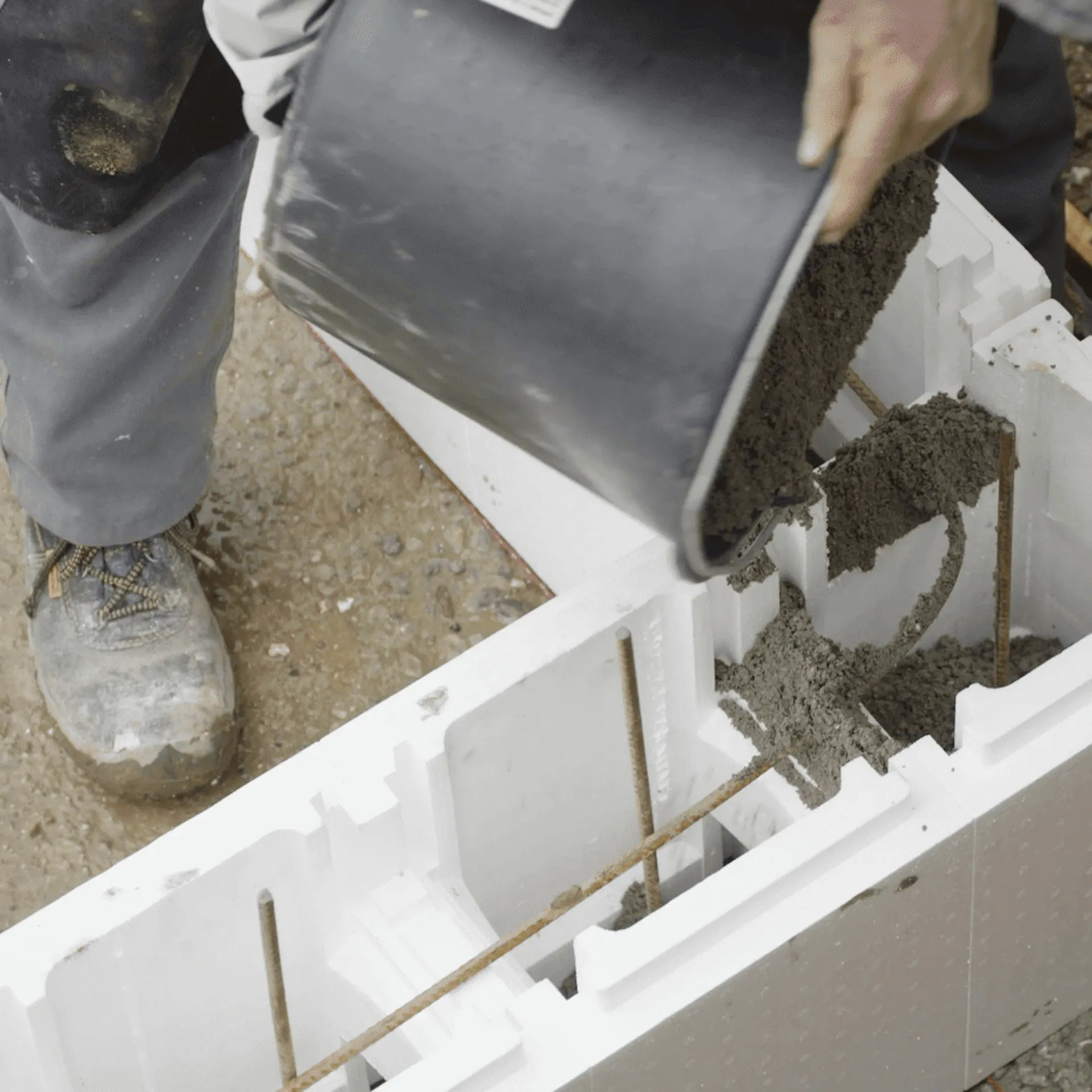 Heimwerker befüllt Polystyrolsteine mit Beton.