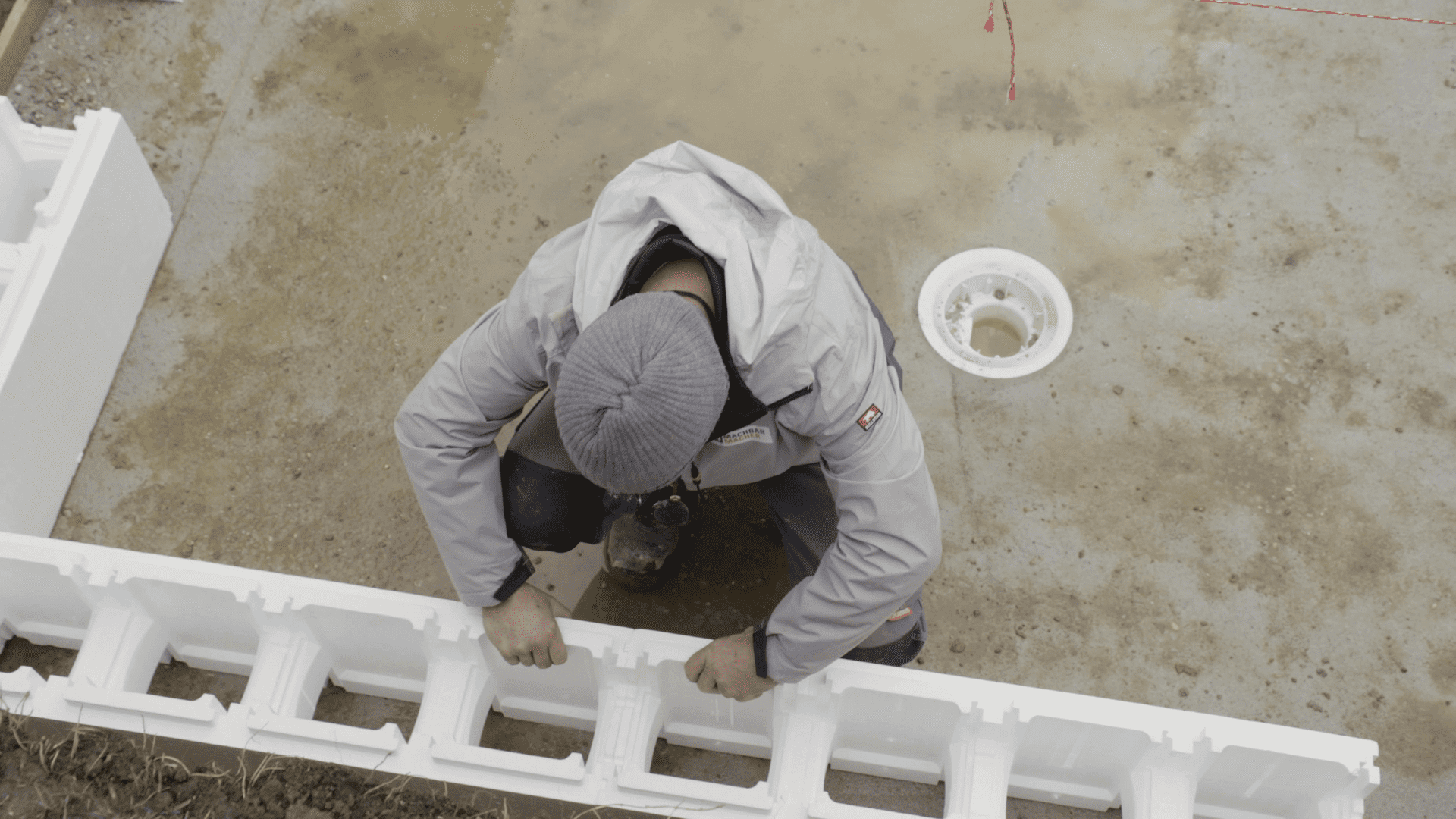 Heimwerker verbindet erste Reihe Polystyrolsteine für Poolbeckenwand.