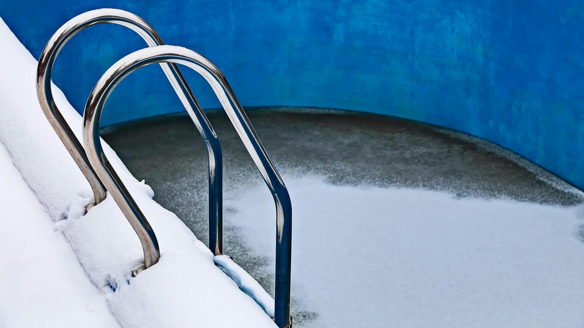 Pool ohne Wasser mit Schnee bedeckt.