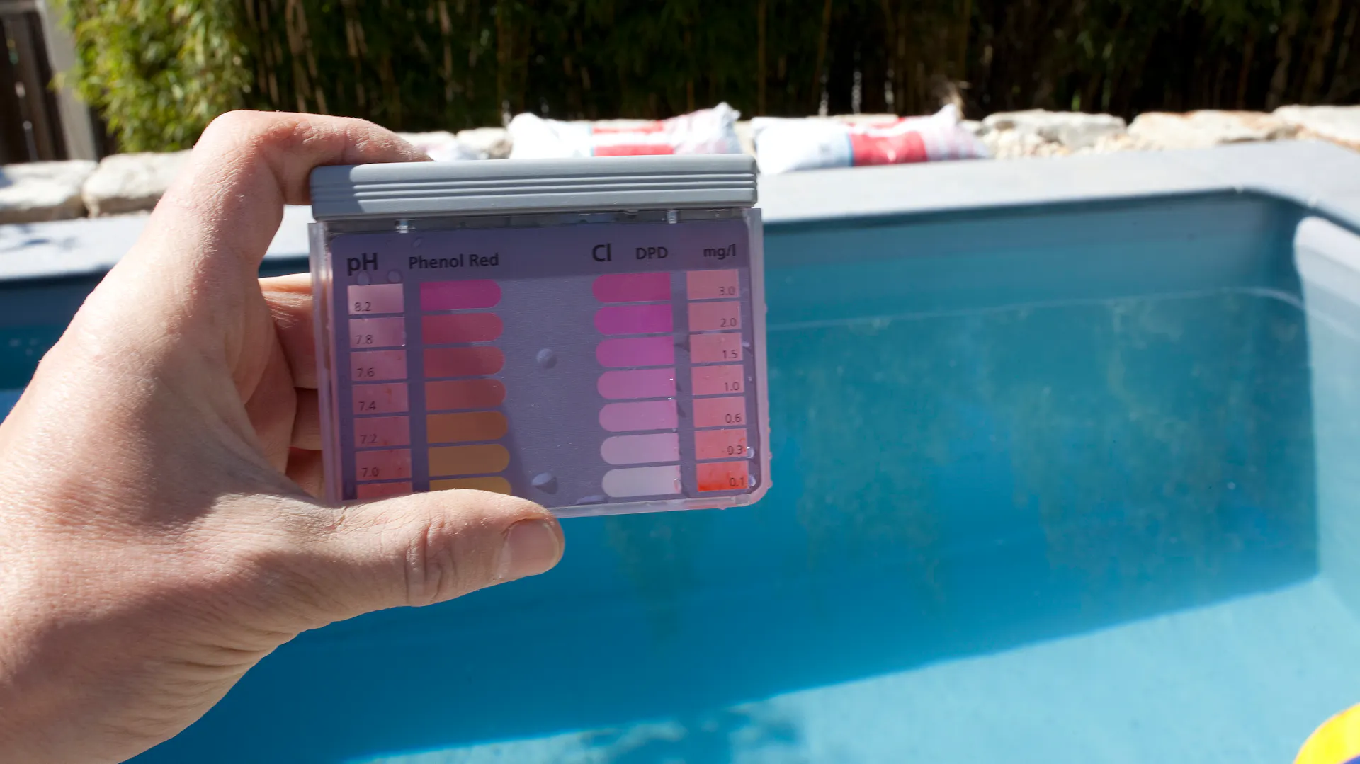 Person hält Teststreifen zur Überprüfung von Wasserqualität in die Luft.