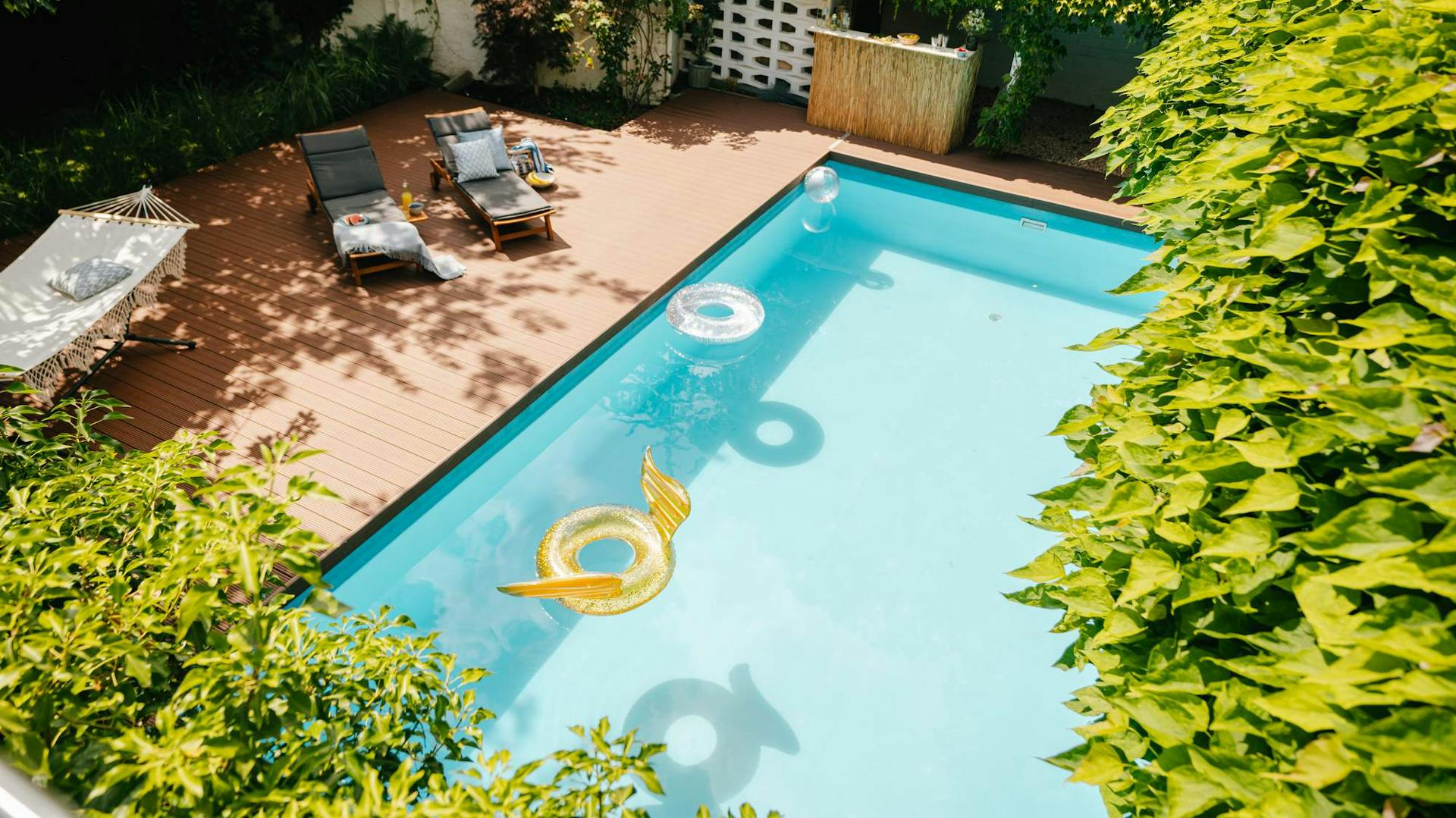Sauberer, gepflegter Pool mit Schwimmtieren und Liegen in Garten