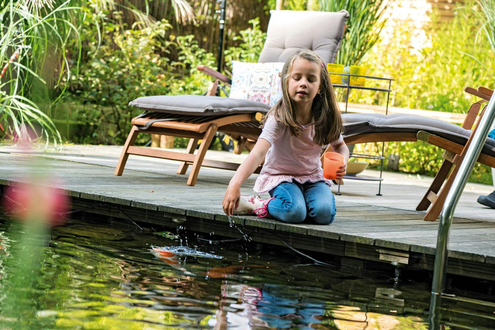 Ragazza seduta sul bordo del laghetto balneabile