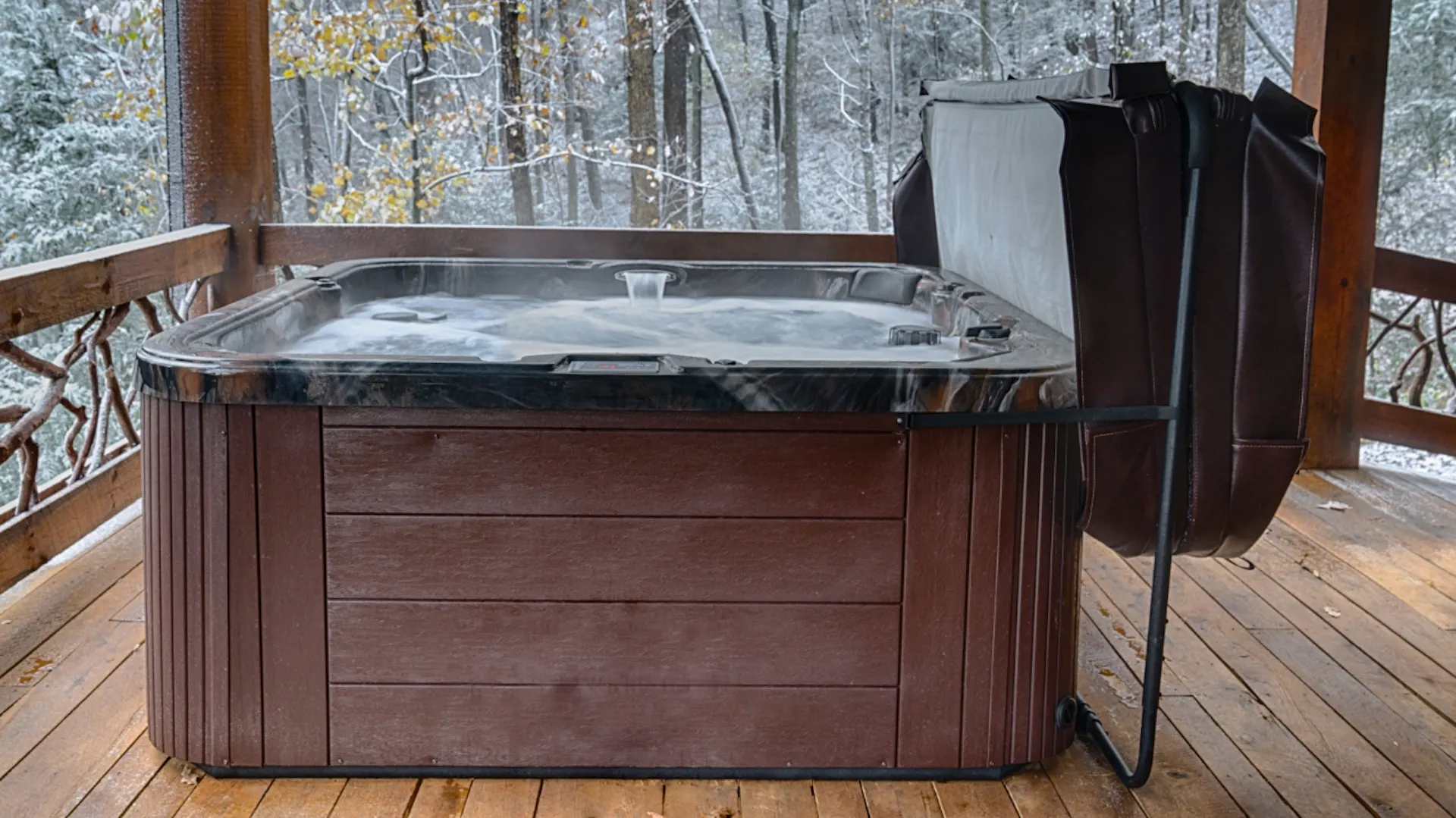 Hölzerner Whirlpool auf Holzterrasse mit aufgeklappter Abdeckung