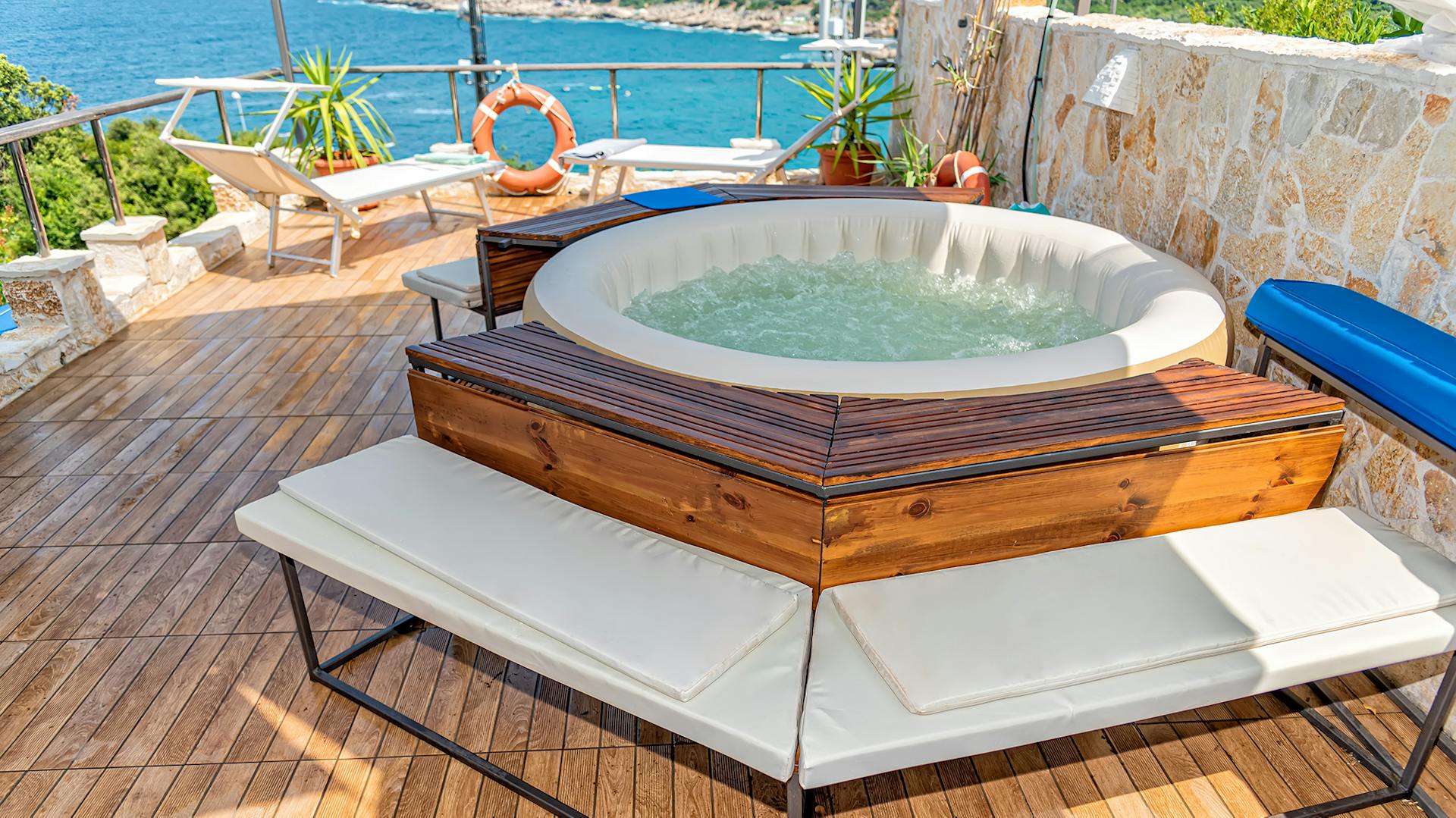 Nafukovacia vírivka s dreveným orámovaním a lavičkou na terase