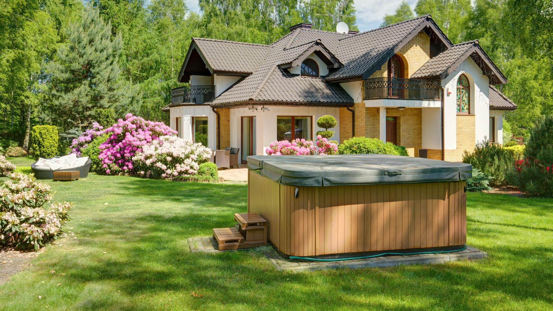 Abgedeckter Whirlpool im Garten vor einem Haus