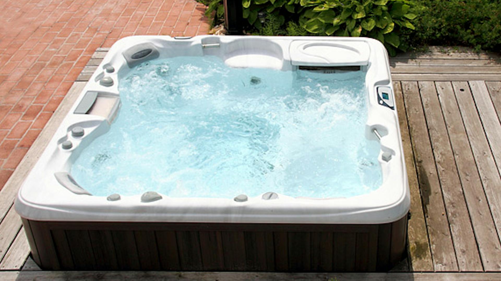 Fest eingebauter und gefüllter Whirlpool auf Terrassendielen
