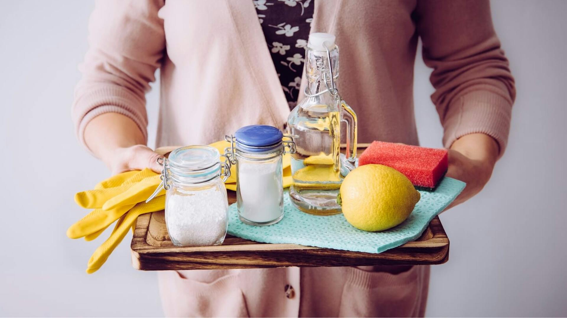 Egy ember egy tálcával, amelyen masszázsmedencék tisztítására alkalmas háztartási vegyszerek vannak