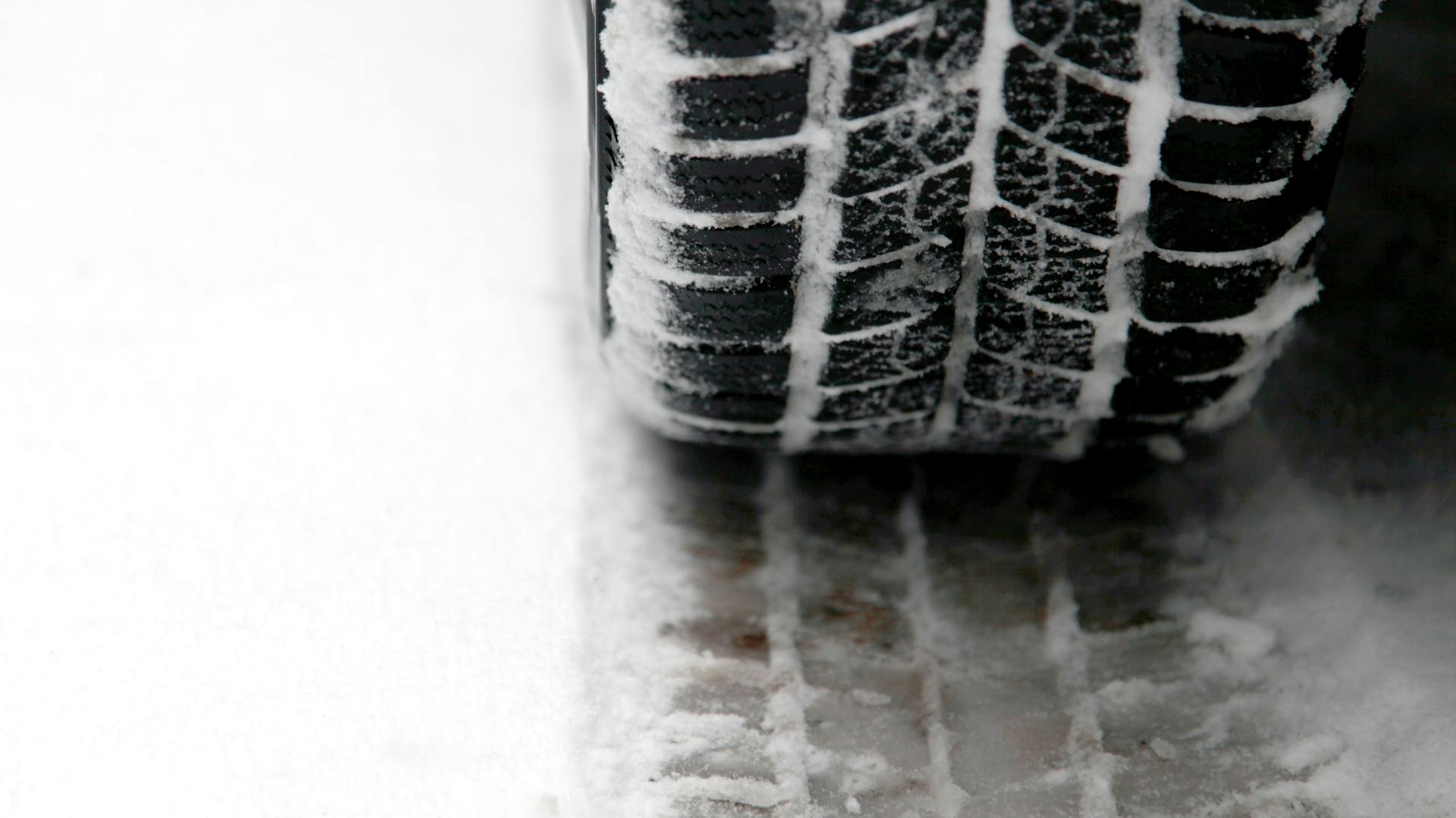 Winterreifen auf Straße mit Schnee.