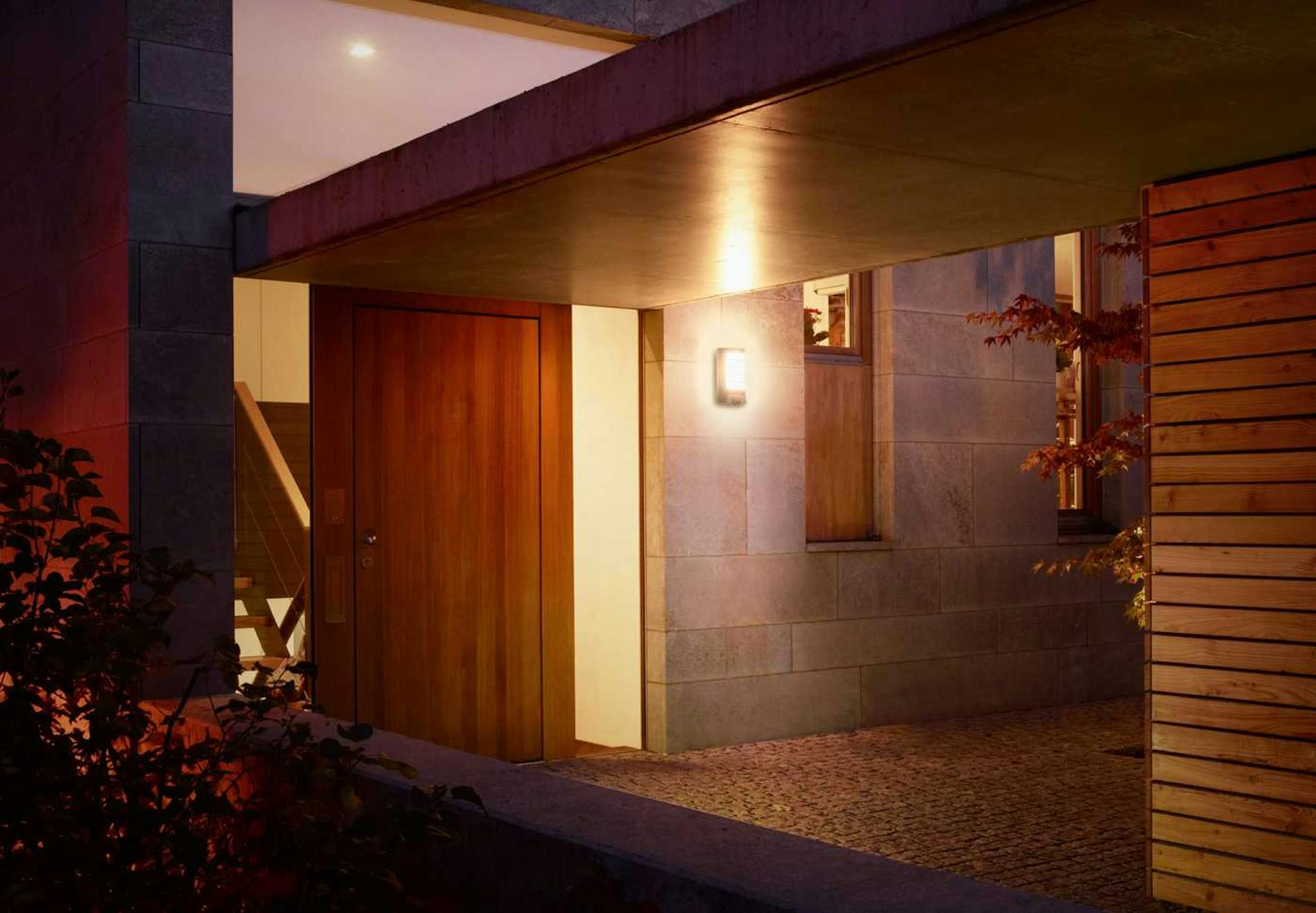 Zona d’ingresso di una casa con pensilina e illuminazione