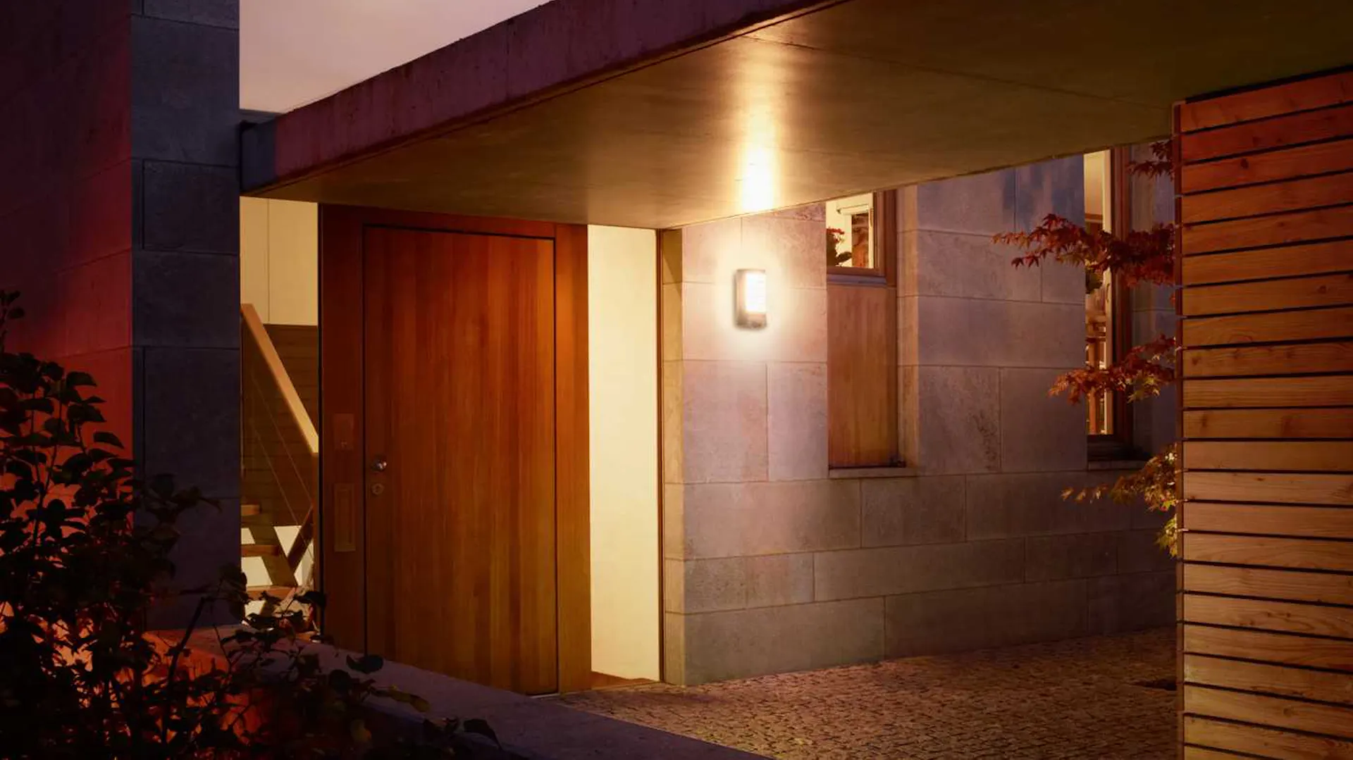 Ház bejárata előtetővel és világítással
