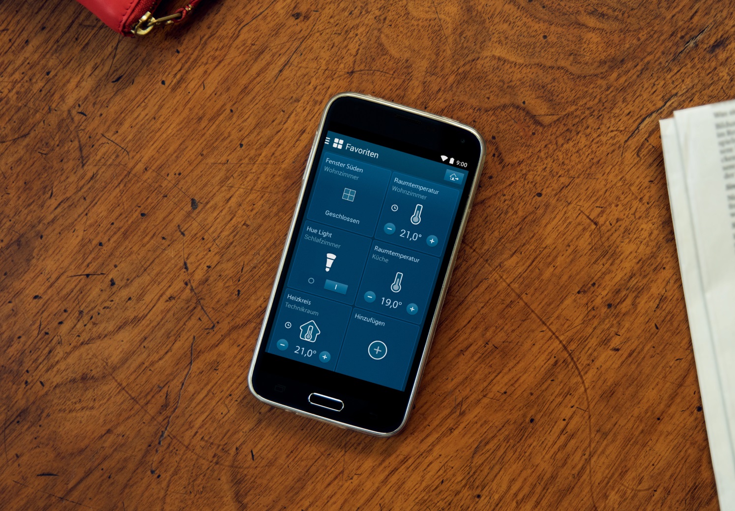 Smartphone mit offener Smart-Home-App auf Holztisch