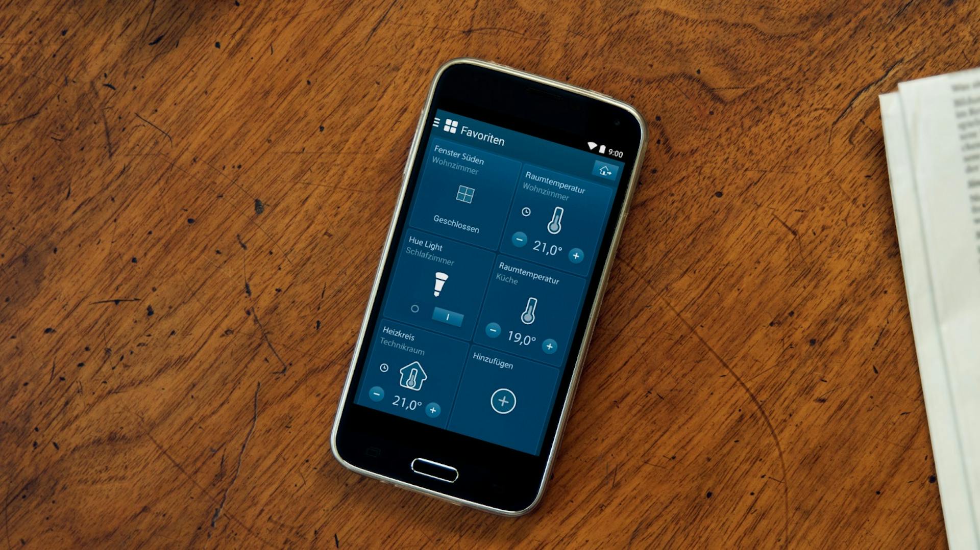 Smartphone mit offener Smart-Home-App auf Holztisch