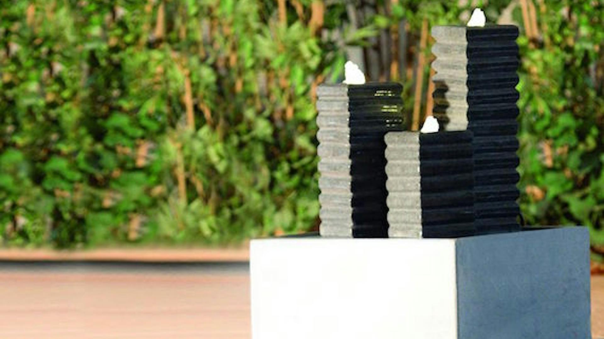 Ein dreiteiliges, puristisch wirkendes Wasserspiel in schwarzem und grauem Stahl.