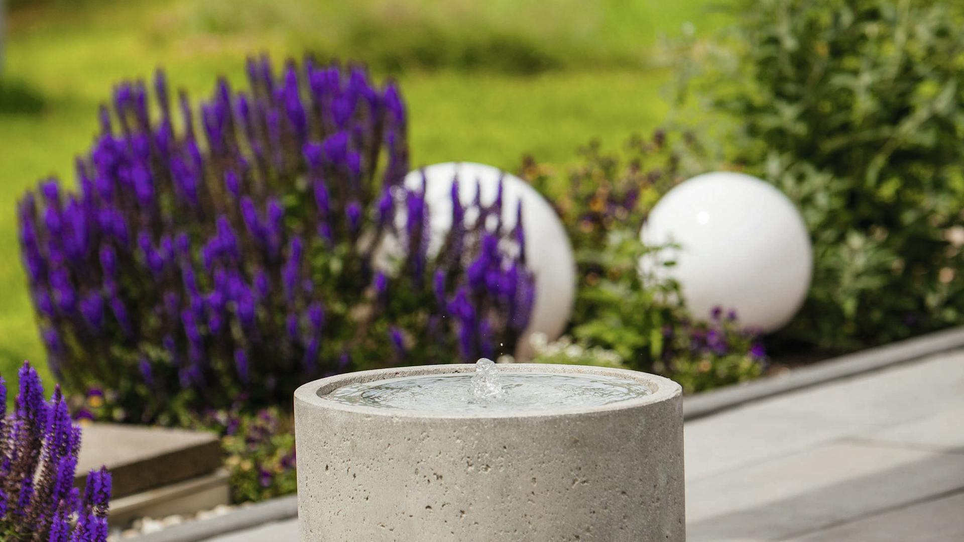 Detailansicht eines Gartenbrunnens auf einer Terrasse.