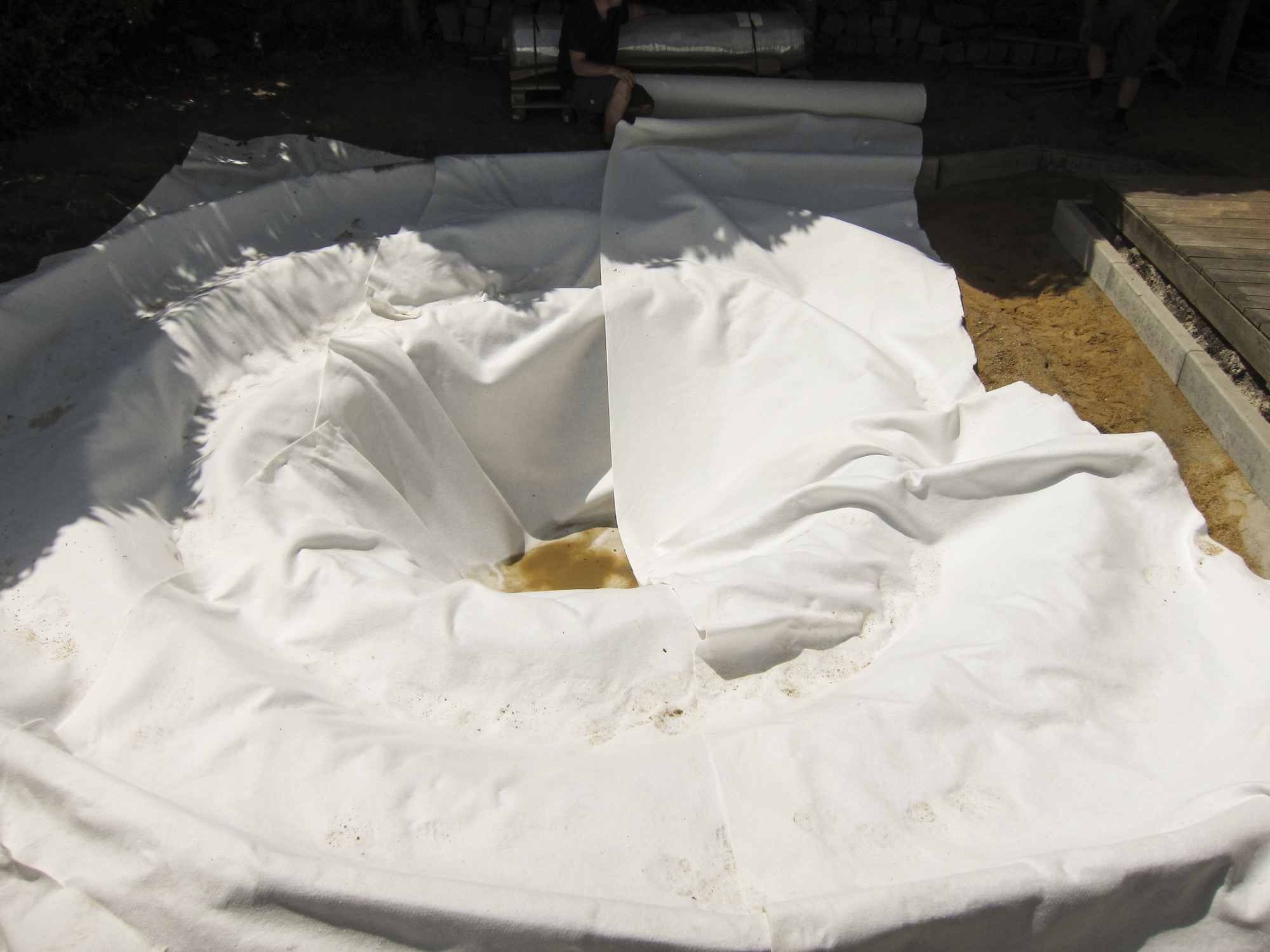 Schutzvlies liegt über den Teichzonen aus.