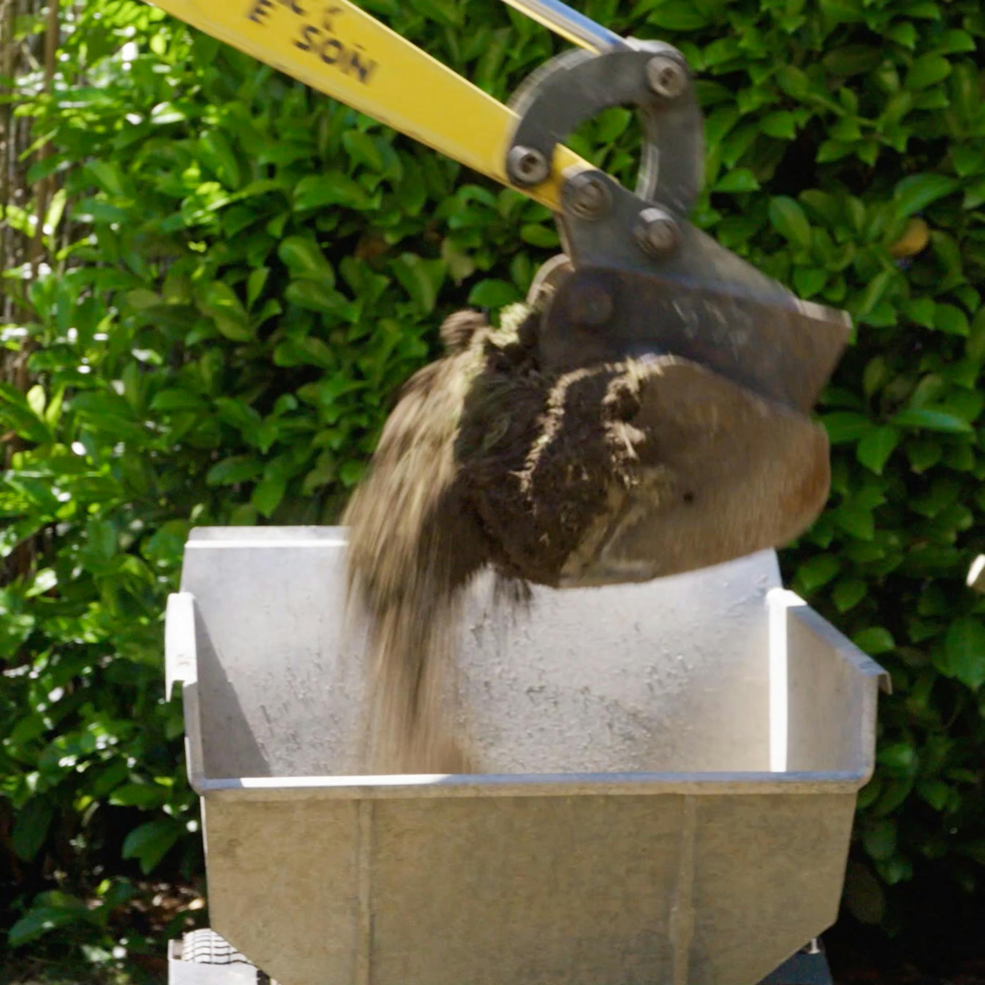 Bagger läd Erde in Dumper ab.