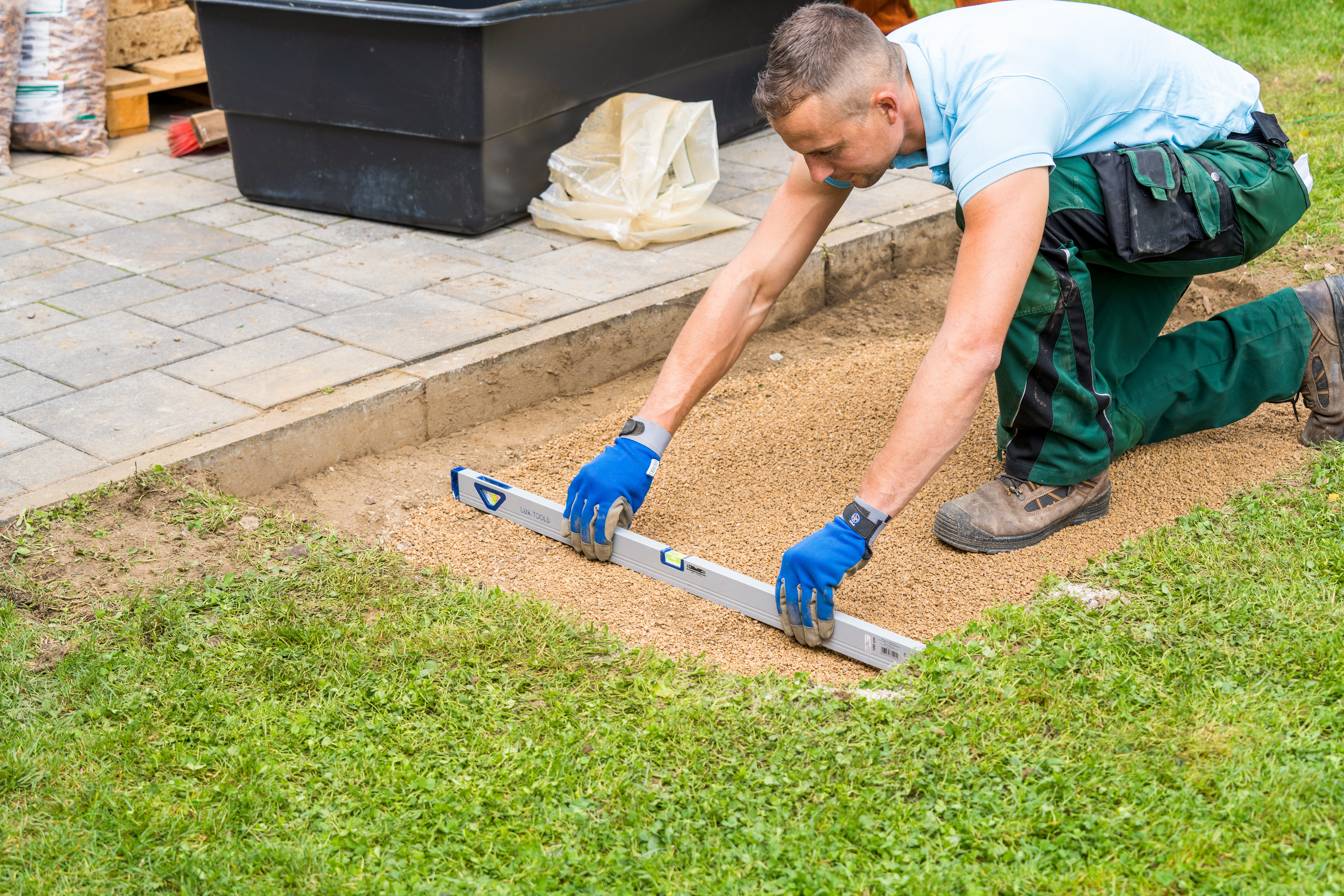 Egy férfi vízmértéket tart egy zúzalékágyon