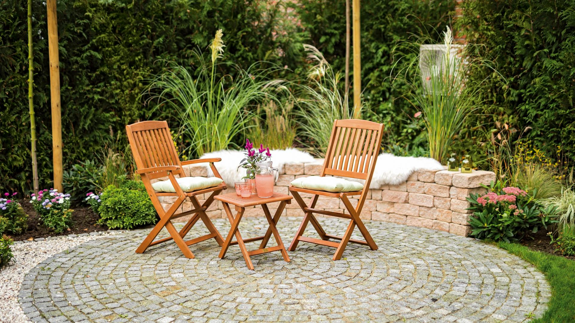 Mit Granitsteinen gepflasterter Bereich mit zwei Stühlen und Tisch