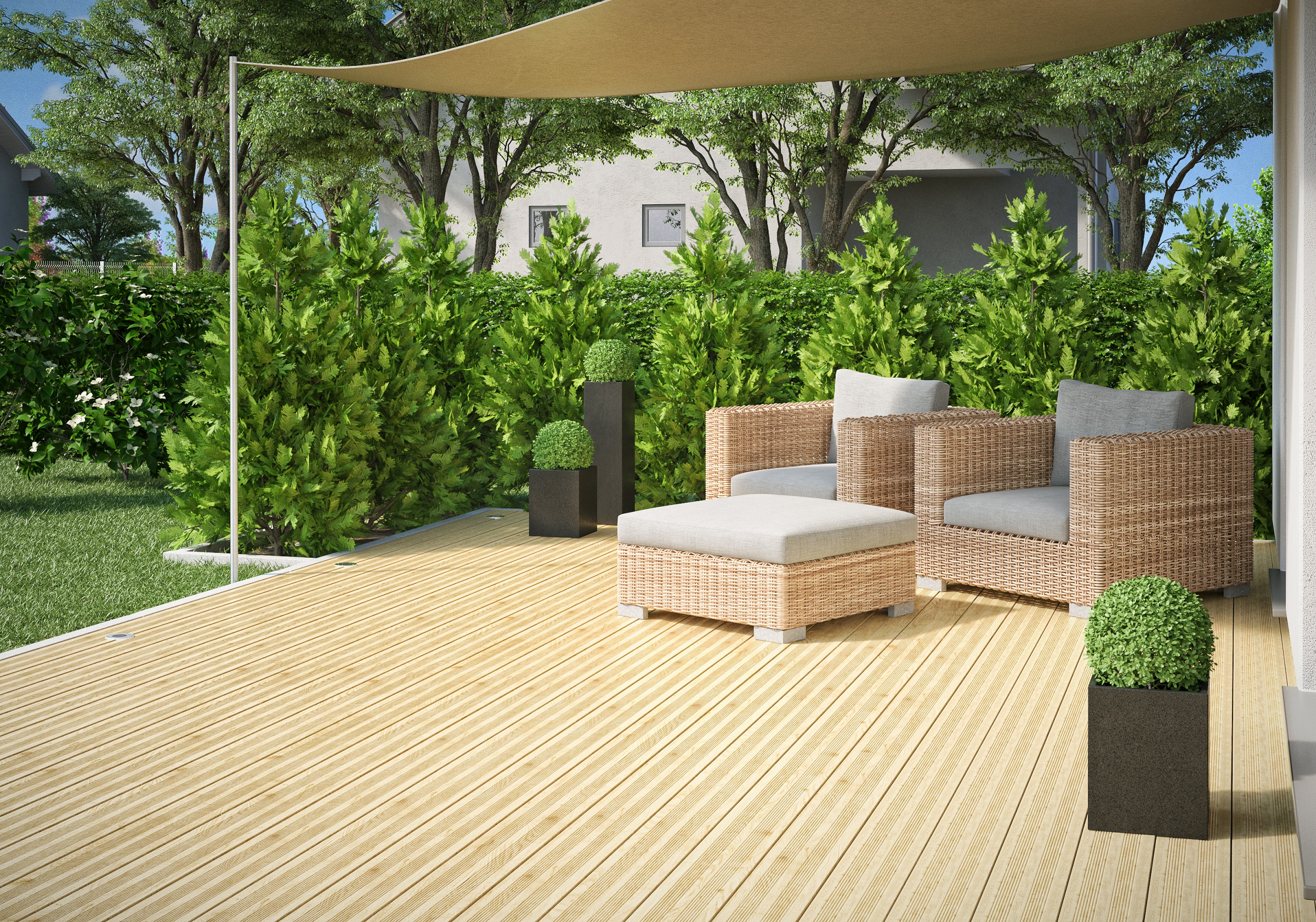 Terrasse mit Loungemöbeln und Sichtschutzhecke