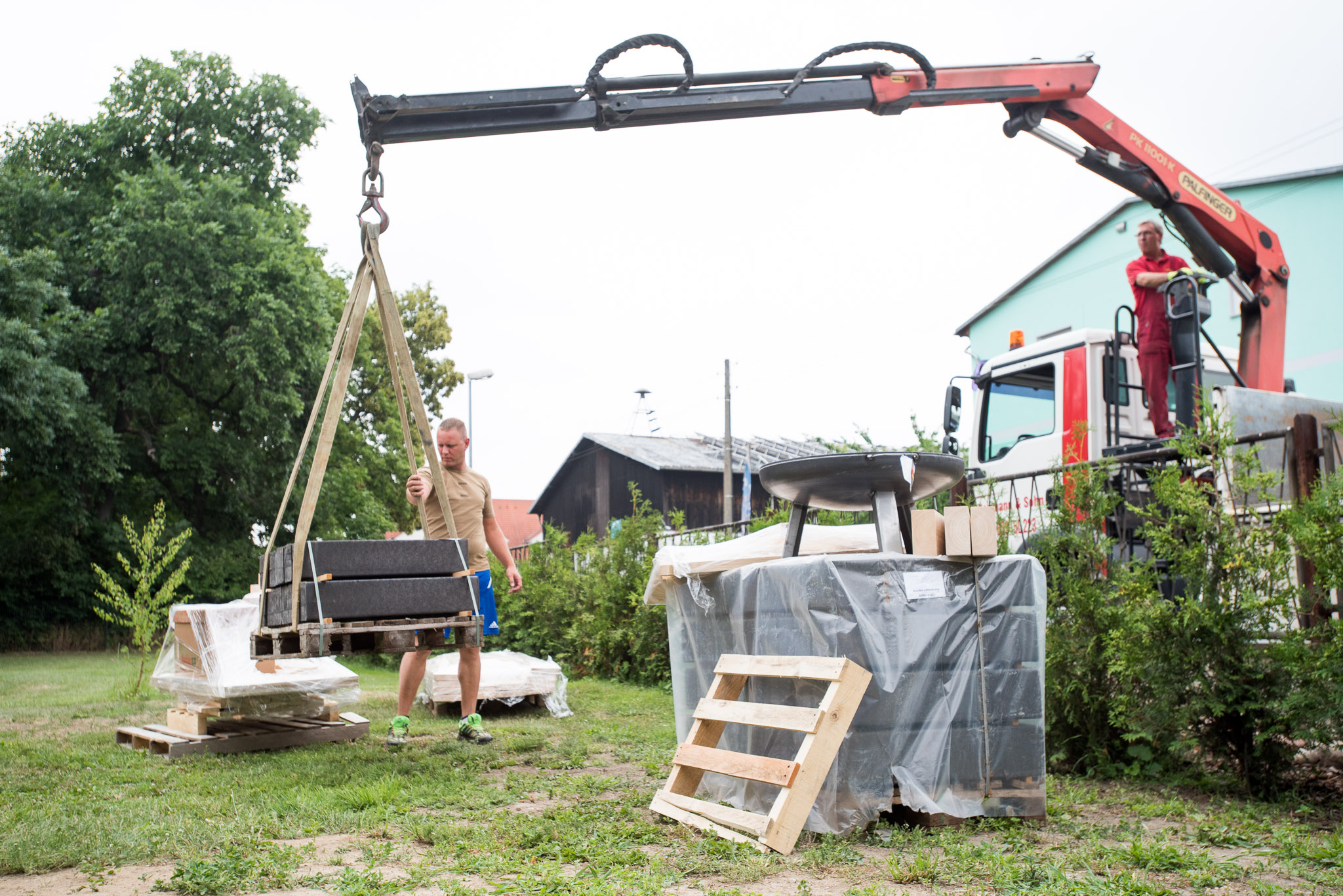 Építőanyagok beszállítása a kertbe daruval