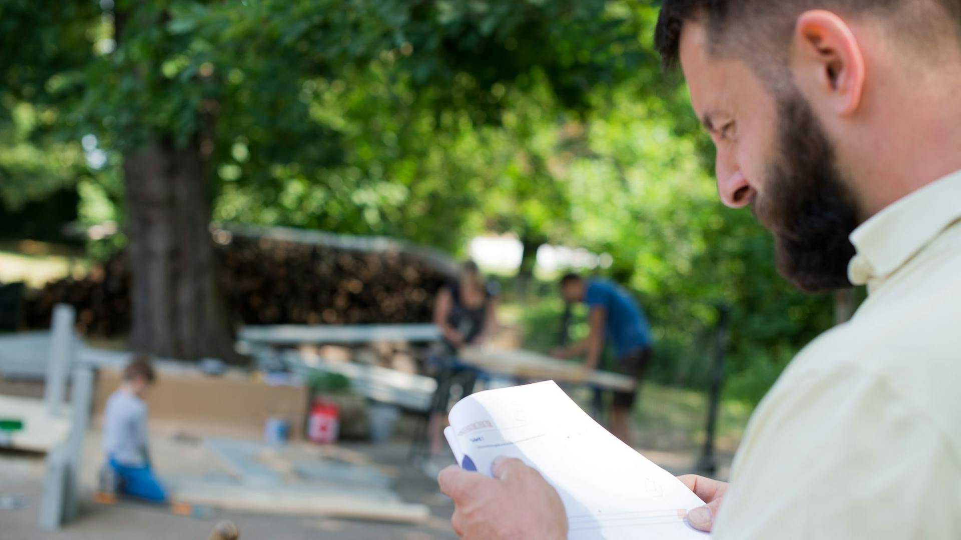 Heimwerker im Garten studiert Unterlagen