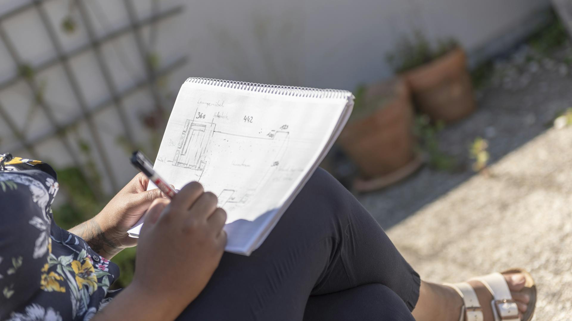 Heimwerkerin erstellt Planungsskizze für Terrasse