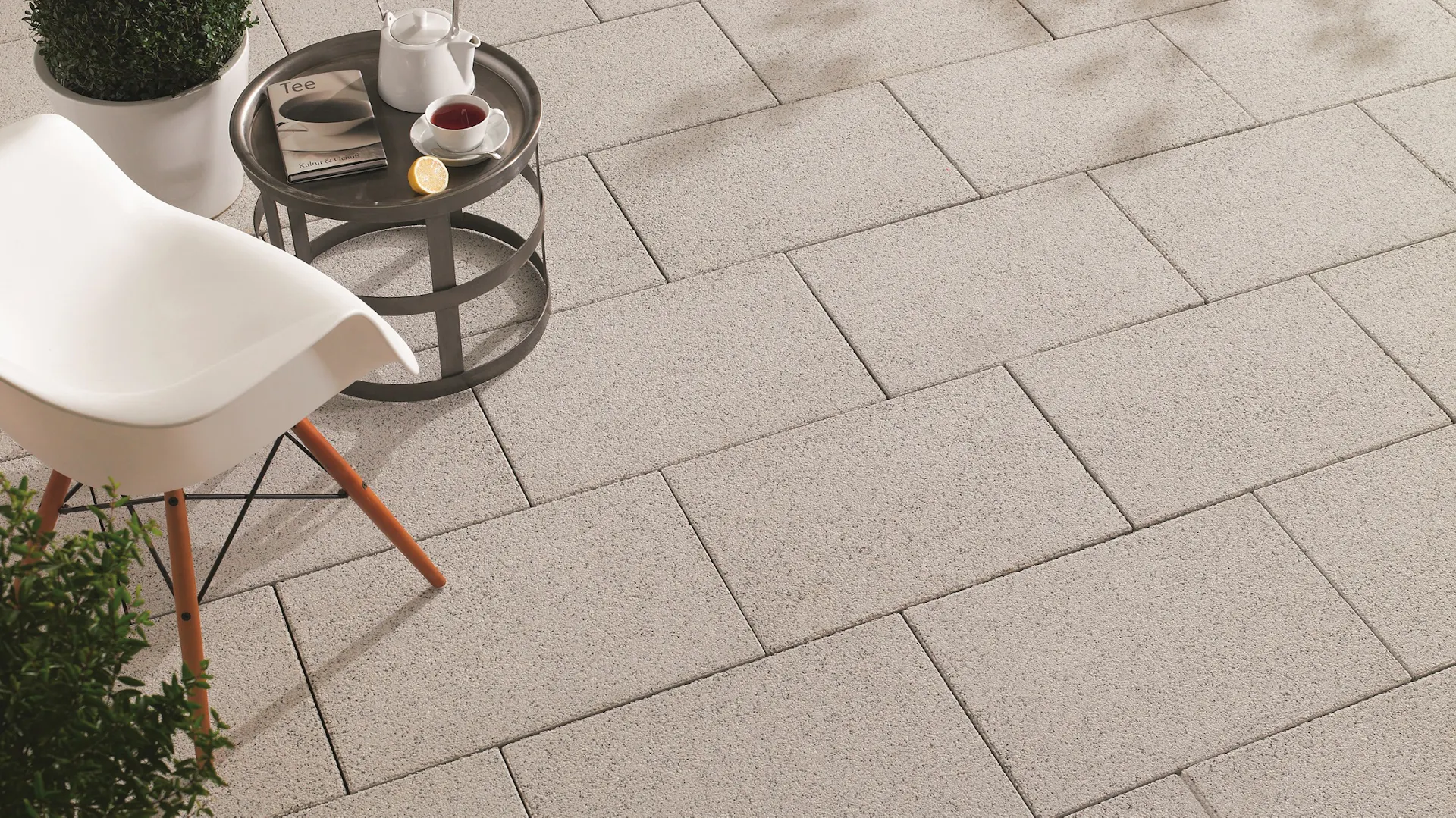 Piastrelle per terrazza su cui sono posizionati una sedia e un tavolino da caffè