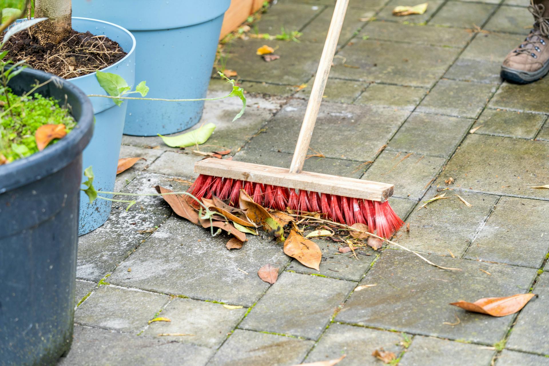 Le piastrele per esterno vengono pulite con una scopa.