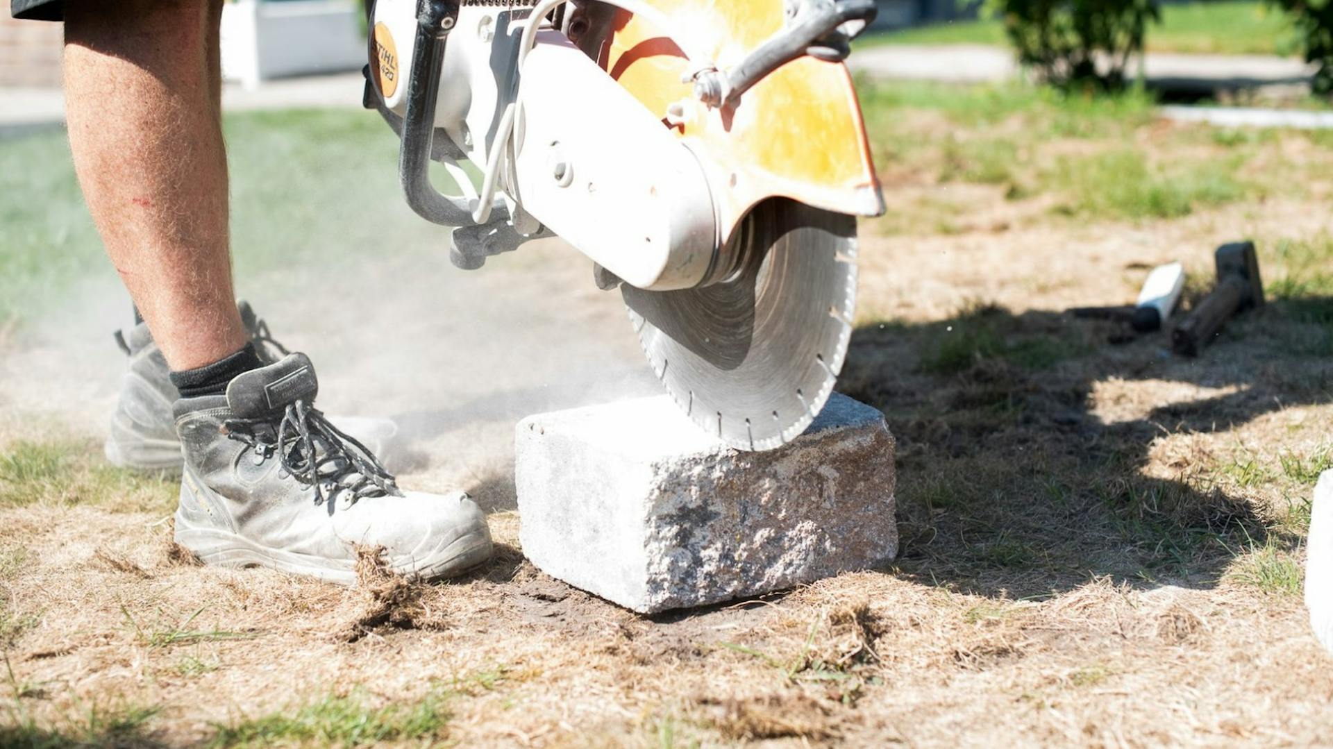 Terrassenplatten mit einem Benzin-Trennschleifer schneiden.