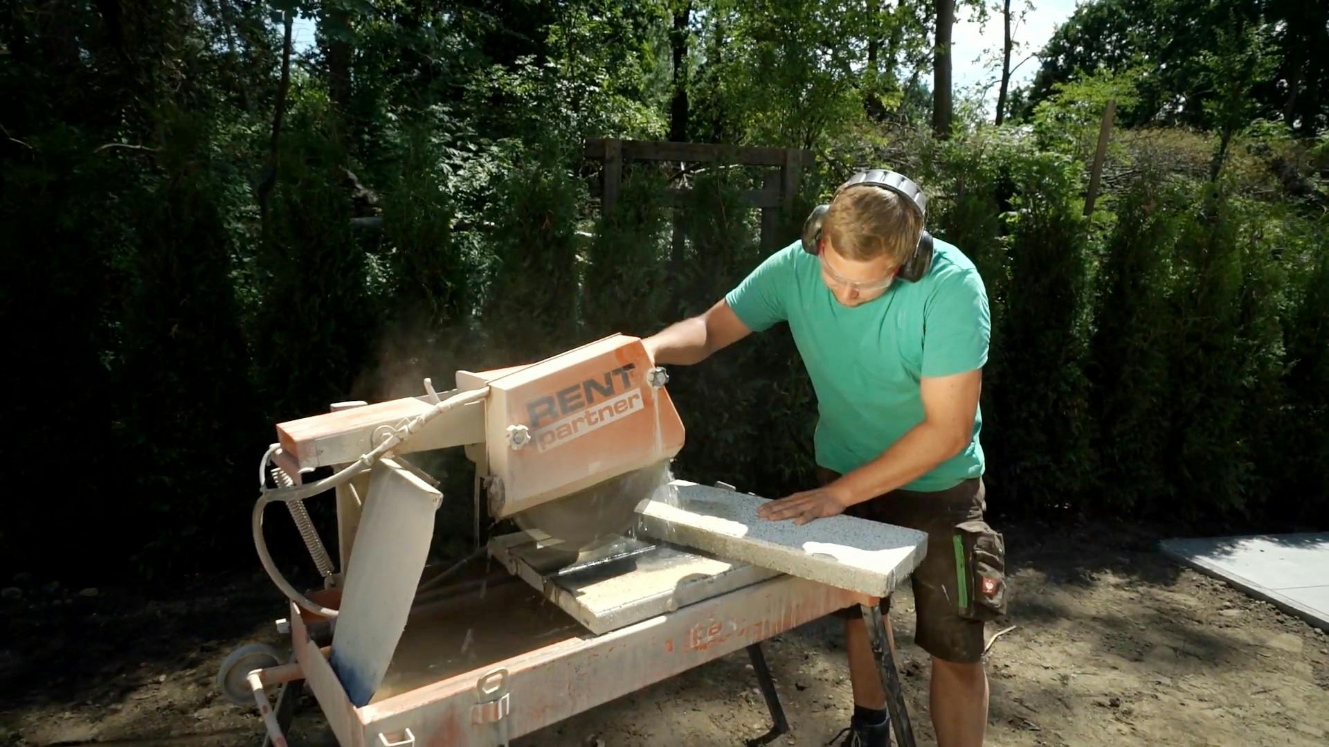Heimwerker schneidet Terrassenplatten mit Nassschneidetisch.